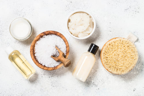 Salz, Öl und Creme auf einem Tisch für die Herstellung von Gesichtspeelings und -masken